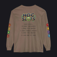 A brown long-sleeve t-shirt with a humorous gaming graphic on the back. The graphic features a 'HOC SLOTS 10' logo in a retro video game font, followed by mock '2026 STATS' text detailing high-order gaming achievements.