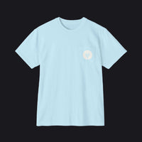 A light blue crewneck t-shirt with a small chest pocket on the left side, featuring a small circular logo with a stylized tree design in white.