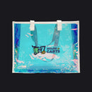 A clear vinyl beach tote bag with a holographic iridescent blue and purple finish, featuring white shoulder straps and a custom printed 'House Carts' logo on the front, set against a plain white background.