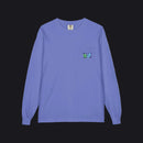 A long-sleeve crewneck shirt in periwinkle blue, featuring a small chest pocket on the left side with a colorful embroidered logo.