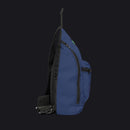A navy blue sling backpack with black straps, zippers, and trim, shown from a side profile view on a solid white background.