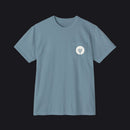 A dusty blue crewneck pocket t-shirt with a small white circular chest graphic showing a stylized plug icon, displayed on a clean white background.