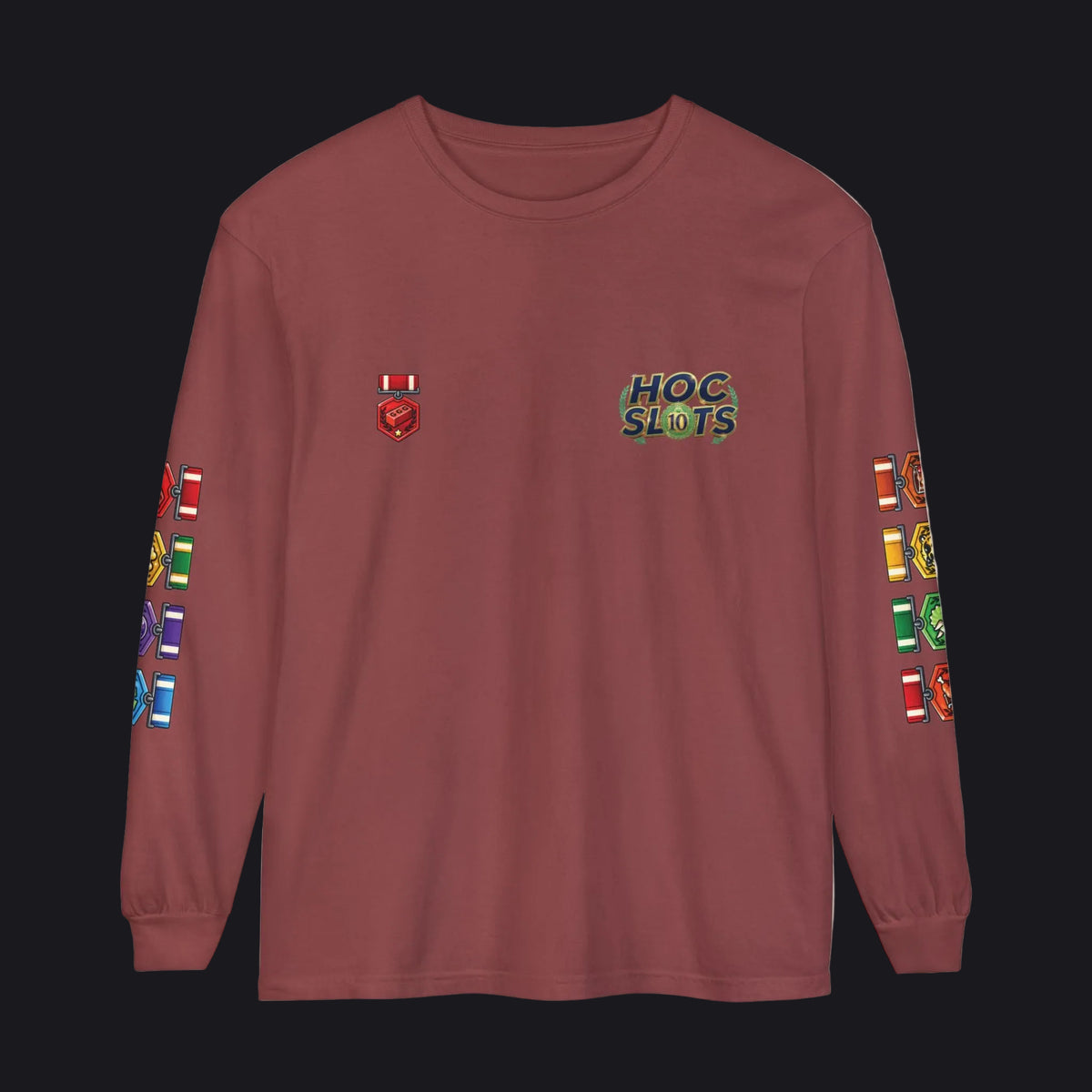 A long-sleeve crewneck t-shirt in a dusty rose or mauve color, featuring a 'HOC SLOTS' graphic on the left chest, a small red and white flag graphic on the right chest, and colorful flag graphics printed down both sleeves.