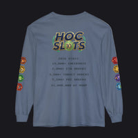 A blue long-sleeve t-shirt with a gaming-themed graphic on the back. The graphic features a 'HOC SLOTS 10' logo in a retro video game font, followed by fake statistics in black text, and colorful hexagonal icons printed down both sleeves.