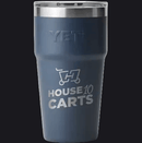 A dark slate blue YETI insulated tumbler with a stainless steel lid, featuring a custom graphic of a shopping cart with the text 'HOUSE 10 CARTS' printed in silver on the front.