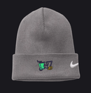 A gray ribbed knit beanie hat featuring a white Nike swoosh on the cuff and a small embroidered graphic with a green trash can, dark blue lettering, and yellow '10' on the front left.
