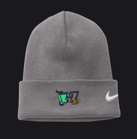 A gray ribbed knit beanie hat featuring a white Nike swoosh on the cuff and a small embroidered graphic with a green trash can, dark blue lettering, and yellow '10' on the front left.