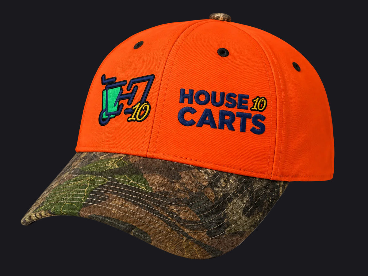 An orange baseball cap with a camouflage-patterned brim, featuring embroidered 'HOUSE 10 CARTS' text and a trash can graphic on the front.
